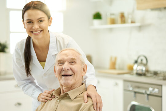 Pleased aged man being visited by a qualified doctor at home
