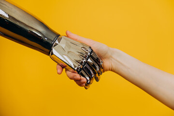 Injured person with stylish contemporary bionic prosthesis arm joins hands with young woman on...