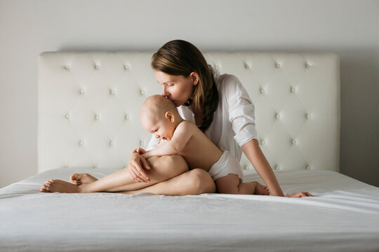 Mother kissing a baby on the head.