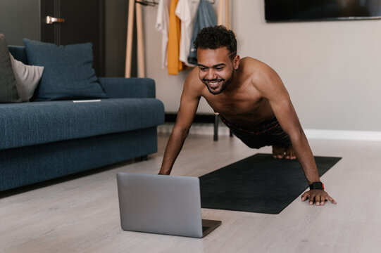 Happy black athlete during online workout at home