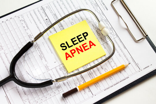 Text Sleep Apnea on a yellow sticker with a stethoscope lying on a folder with medical documents