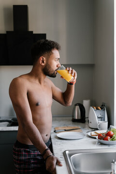 Ethnic man drinking juice in morning