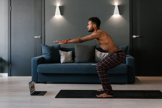 African American man squatting near laptop