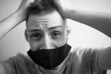 Young guy in black mask is afraid