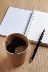 Cup of coffee, notepad and pen