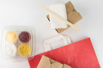 Food delivery service concept. Asian food in eco paper take away boxes with sauces. Meal diet plan for daily ready menu.