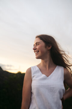 Young woman smiling and laughing outside at sunset