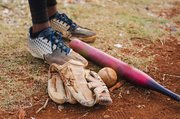 boy with brown skin and latin origin playing baseball in the park with ball, glove and bat, dark...