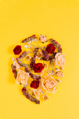 Flowers of different colors, egg-shaped, on a yellow background,  Easter, copy space