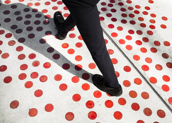 Elegant man walking on a polka dots surface
