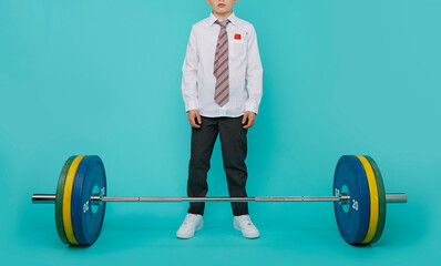 Young child body builder stands over a very heavy barbell