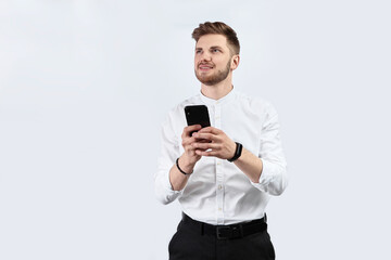 Naklejka premium A man in white shirt using smartphone and excited