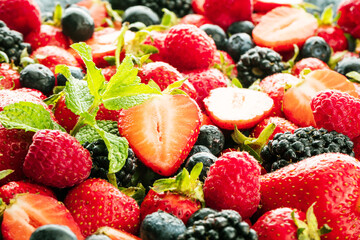 Berries colorful assorted mix of strawberry, blueberry, raspberry, blackberry on dark background