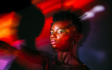 Black african woman posing in the studio with colorful lights