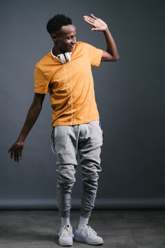 Young black man wearing headphones and dancing