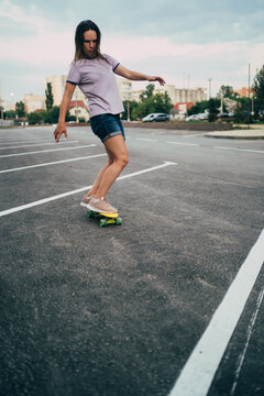 Urban activity: young woman ridding on a skateboard