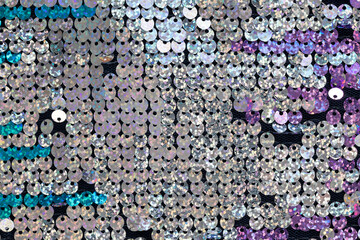 Background, silver sequins material macro, close-up, top view, flatly. Trendy texture with copy space. Celebration, holidays, fashion concept. For social media, blog, website. Horizontal
