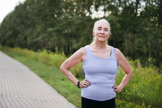 Senior woman is resting in the park after a run.