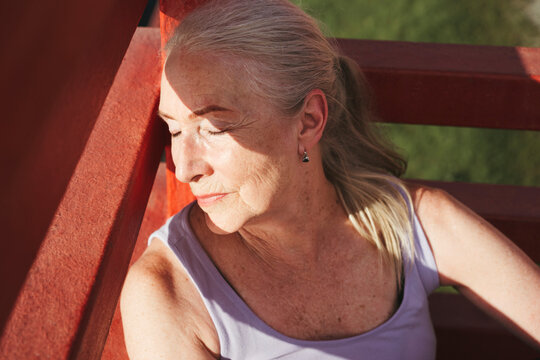 Senior woman is resting in the park after a run.