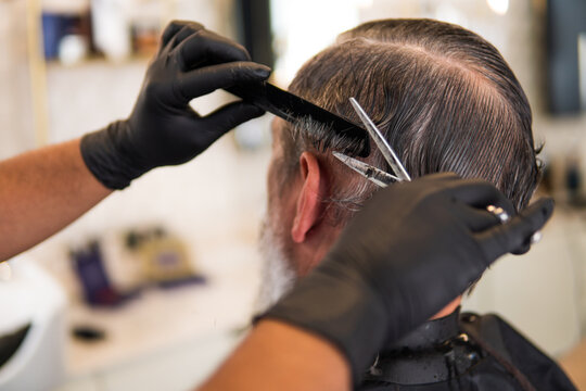 Hairstylist cutting man's hair