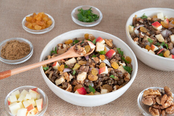 Bowl of vegetarian mixed salad, with lentils, apples, nuts and spices
