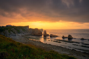 Hermosa vista a&eacute;rea del atardecer en una playa de rocas en la Arn&iacute;a de Santander, Espa&ntilde;a, en los urros de Liencres de costa quebrada
