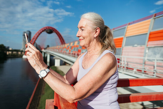 Senior woman takes selfies with a smartphone.