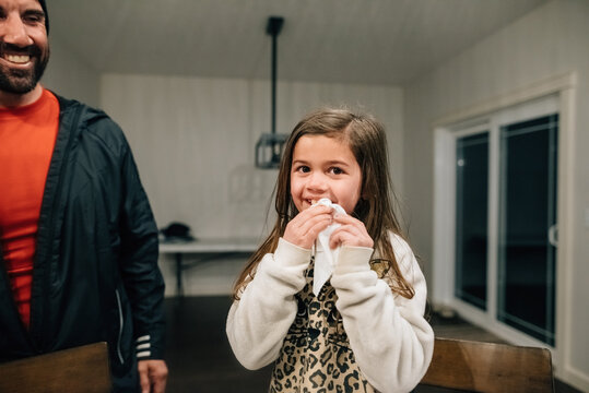 Dad pulling daughter's loose tooth.