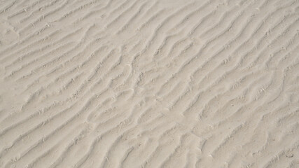 Natural sand pattern on flat sandy beach during low tide.