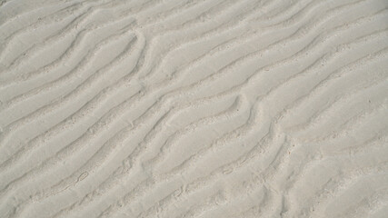 Natural sand pattern on flat sandy beach during low tide.