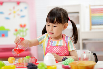 young  girl pretend play food preparing at home