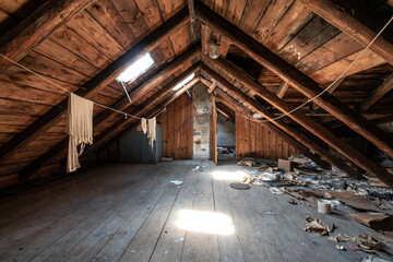 Attic room with clothesline, wooden trim and junk on the floor