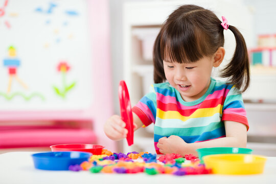 young girl play math and color sorting fine motor skill game for  homeschooling