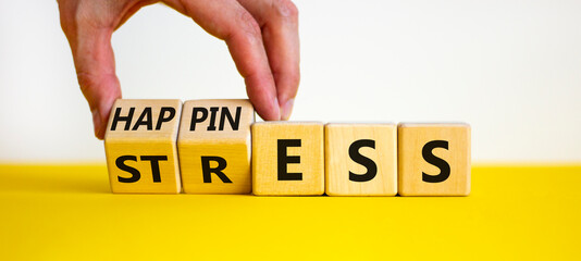 Happiness instead of stress. Businessman turns a cube and changes the word 'stress' to 'happiness'. Beautiful white background. Business, psychological and happines or stress concept. Copy space.