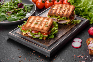 Delicious sandwich with crisp toast, ham, lettuce and tomatoes