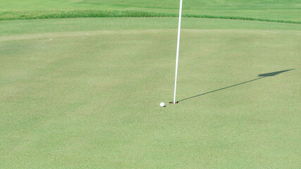 top view of golf hole and the shadow of golf flag.selective focus