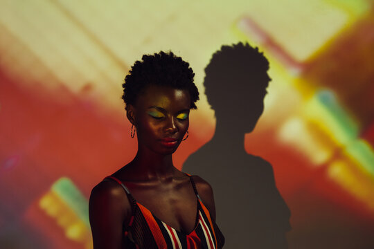 Black african woman posing in the studio with colorful lights