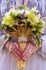 Stylish eclectic wedding bouquet in the bride hands