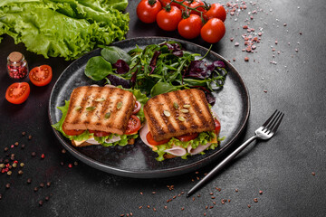 Delicious sandwich with crisp toast, ham, lettuce and tomatoes