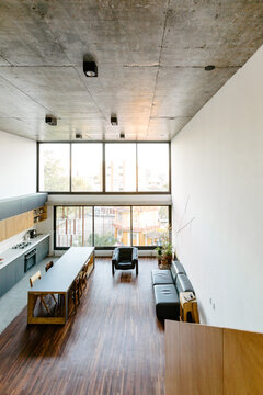 View from staircase in a loft painted in gray with concrete ceiling and wood floor