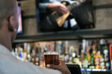 Man In Bar Watching Livestream Concert With A Beer