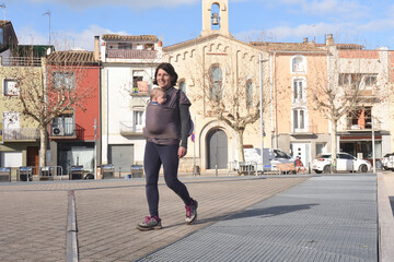 portrait of a woman carrying her son exercising in a city