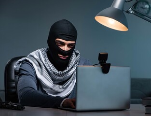 Hacker wearing balaclava mask hacking computer