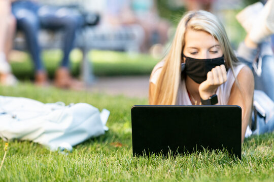 Covid: Co-Ed Laying In Grass Taking Web Based Class