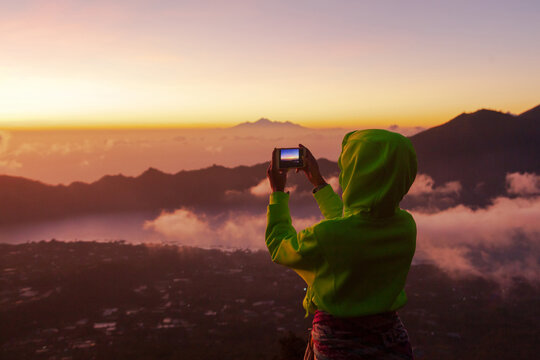 Woman photographs the landscape on the phone