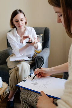 Crop woman drawing during psychotherapy session