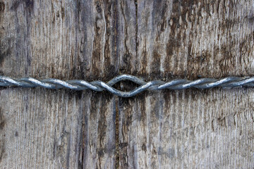 Old twisted wire on a wooden background.