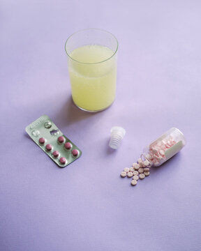 pills next to a glass of medicine