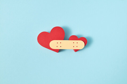 Paper plaster glues two papercraft red hearts.