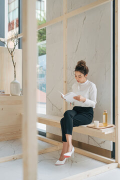 Beautiful girl drinking tea and reading a book.